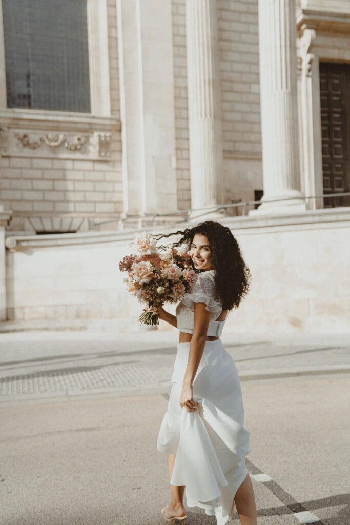 Bride crossing street with her flowers in London