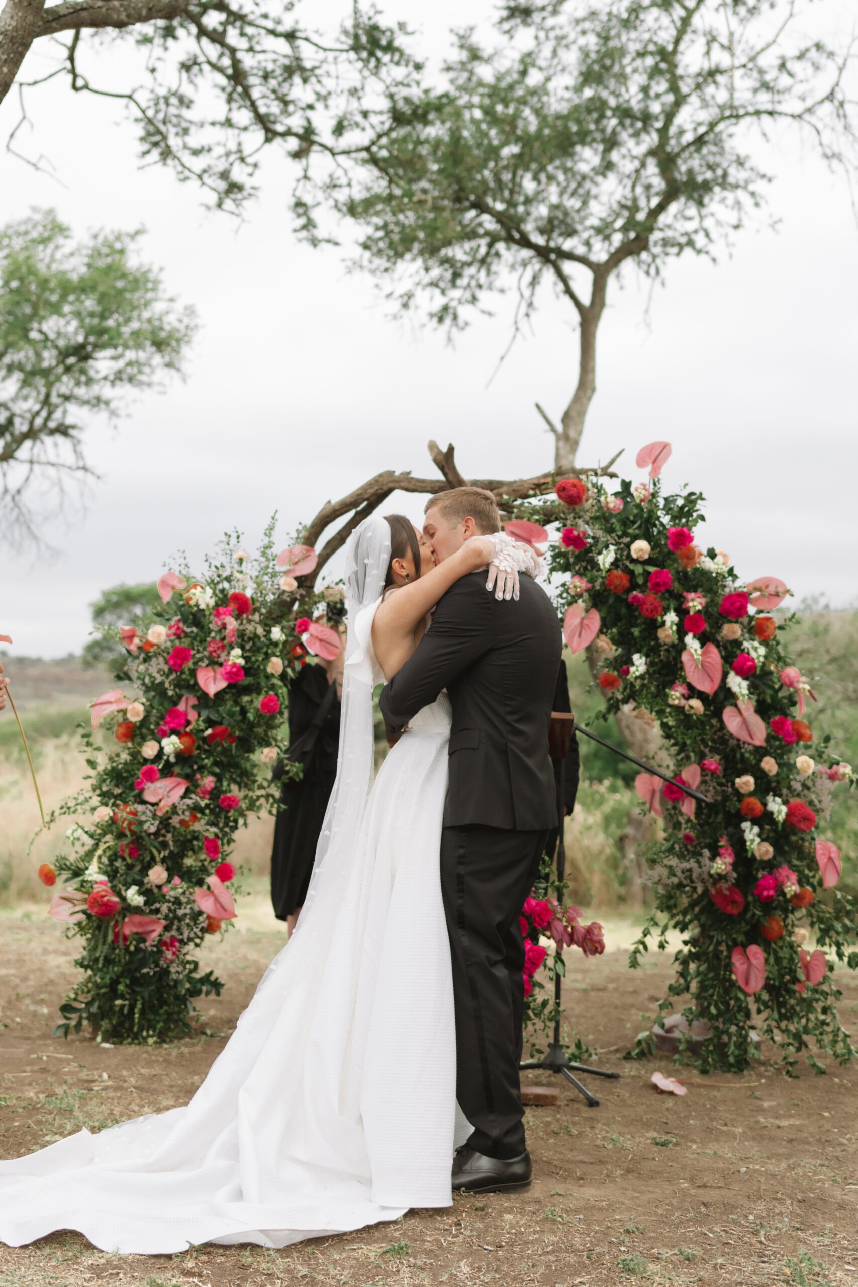 Bridal couple share first kiss at their trendy, pink and floral wedding in Cape Town