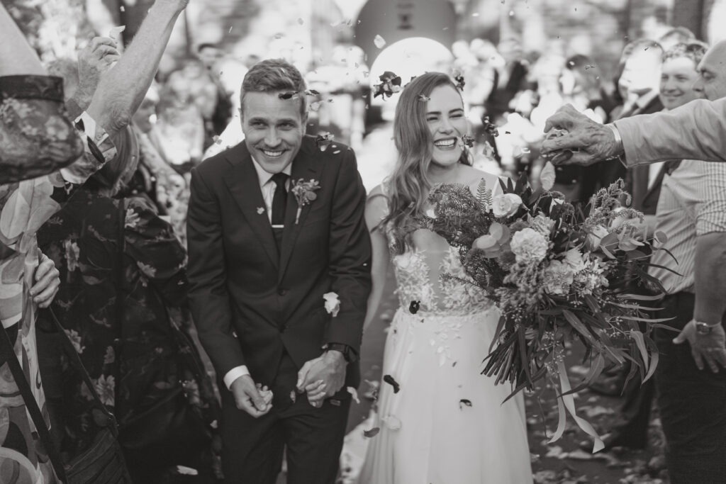 Bride and groom in confetti tunnel