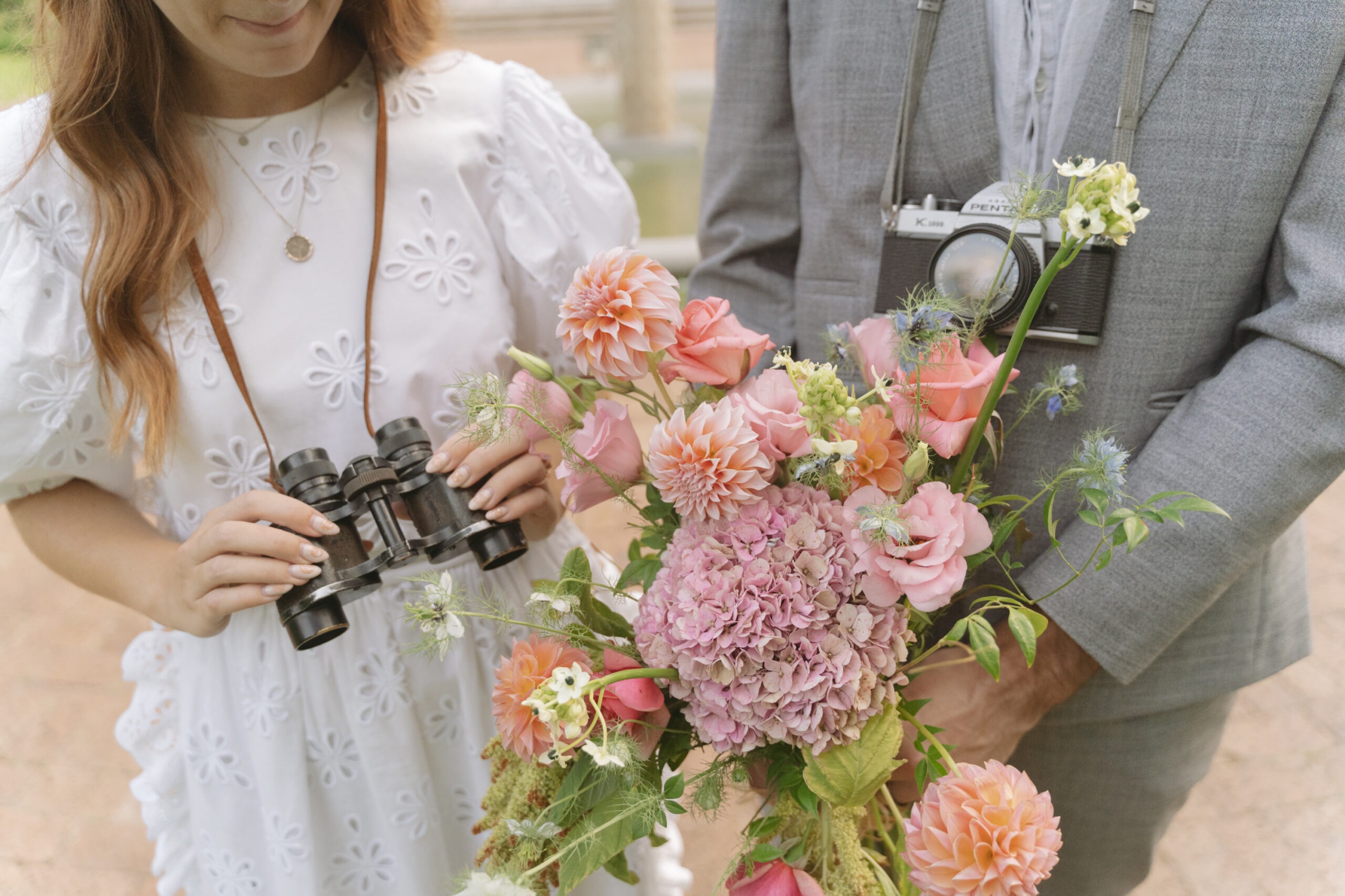 Bride and groom holding pink flowers.