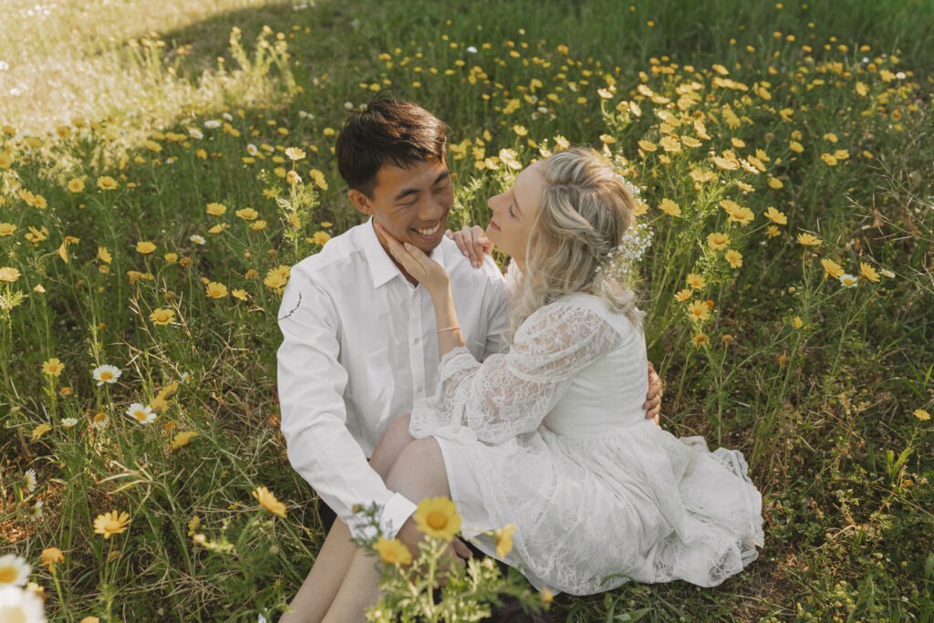Candid and emotive photography of multi-racial couple surrounding by wild flowers in Cape Town