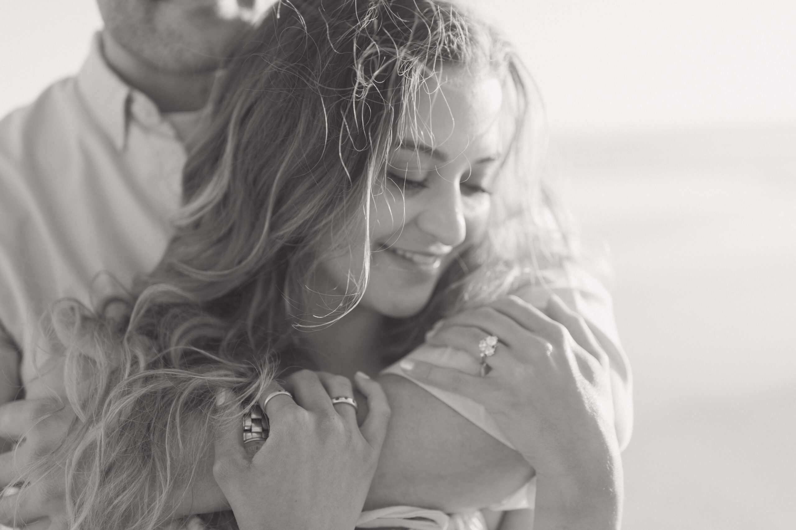 Engaged couple cuddling on beach in Cape Town